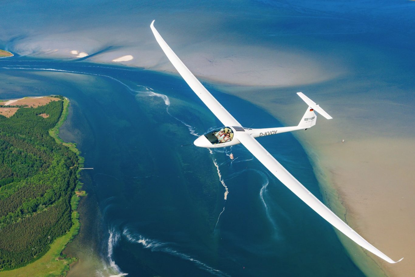 Air-to-Air Luftbild einer Picchio über dramtischem Himmel im Sonnenuntergang Ein kleines Flugzeug schneidet durch Wolken bei Sonnenuntergang.