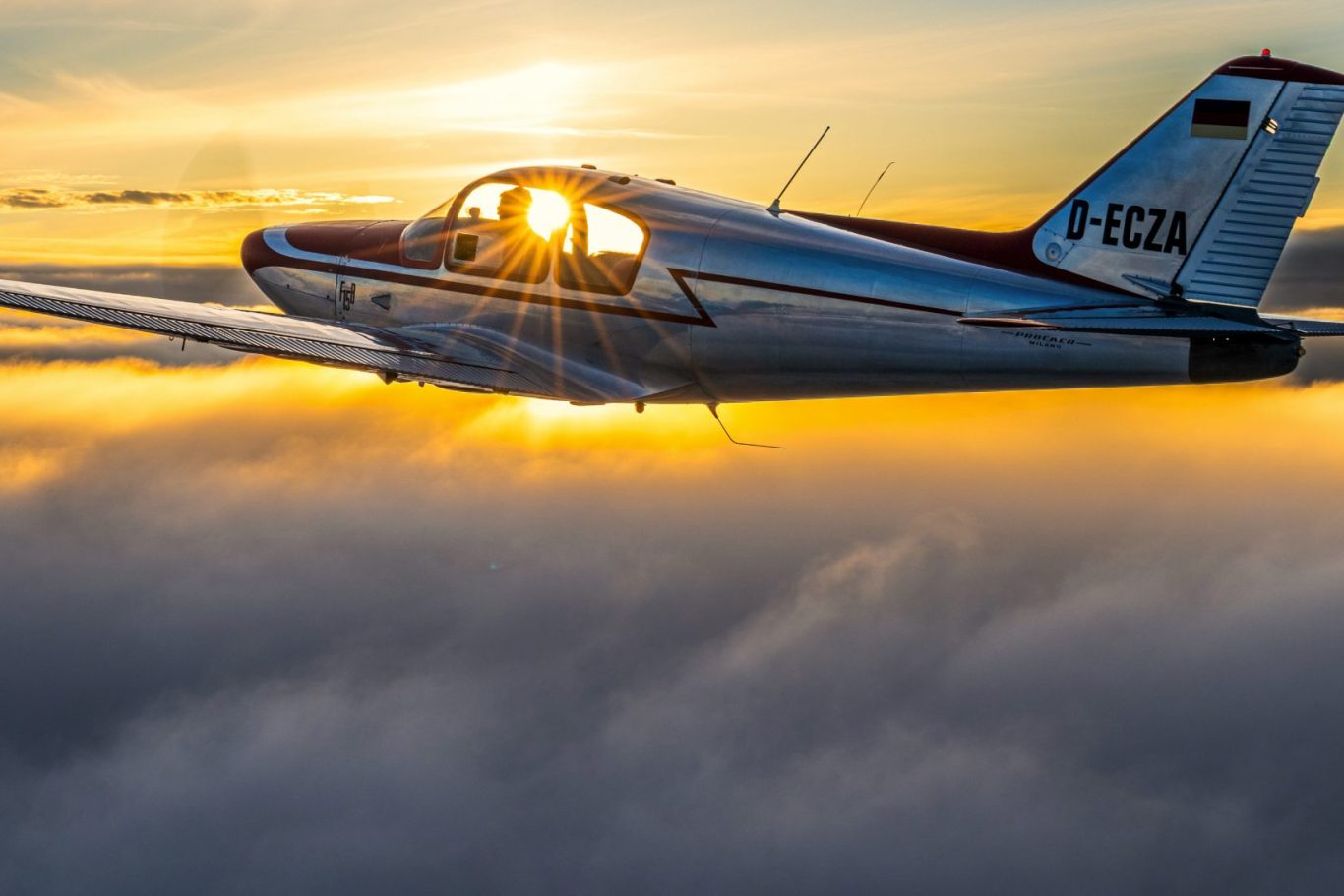 Air-to-Air Luftbild einer Picchio über dramtischem Himmel im Sonnenuntergang Ein kleines Flugzeug schneidet durch Wolken bei Sonnenuntergang.